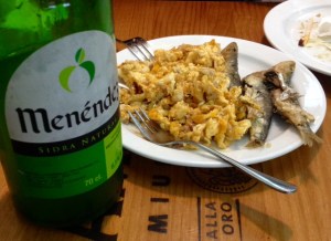 A bottle of Asturian cider with complementary tapa.
